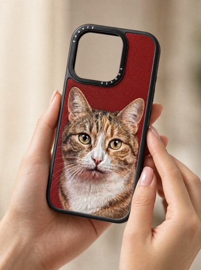 Elegant hands holding a Youvfy custom iPhone case with a tabby cat portrait on bold red