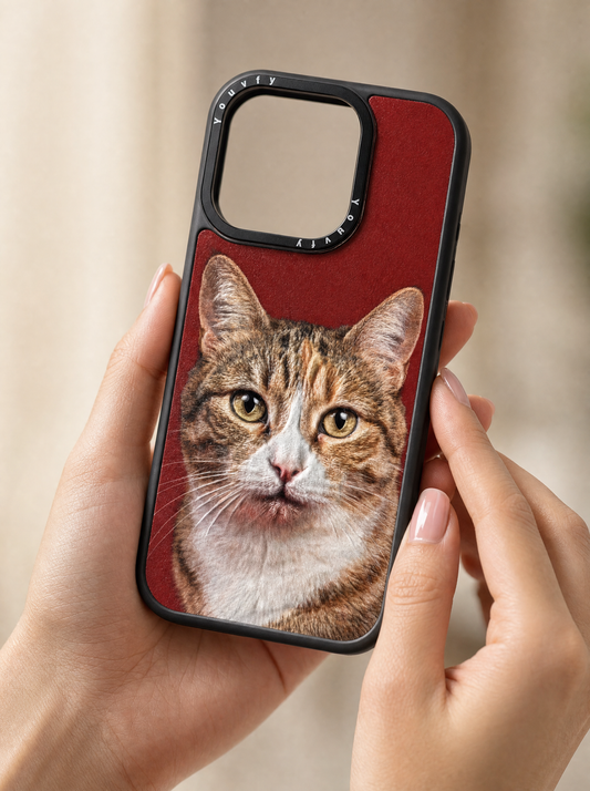 Elegant hands holding a Youvfy custom iPhone case with a tabby cat portrait on bold red