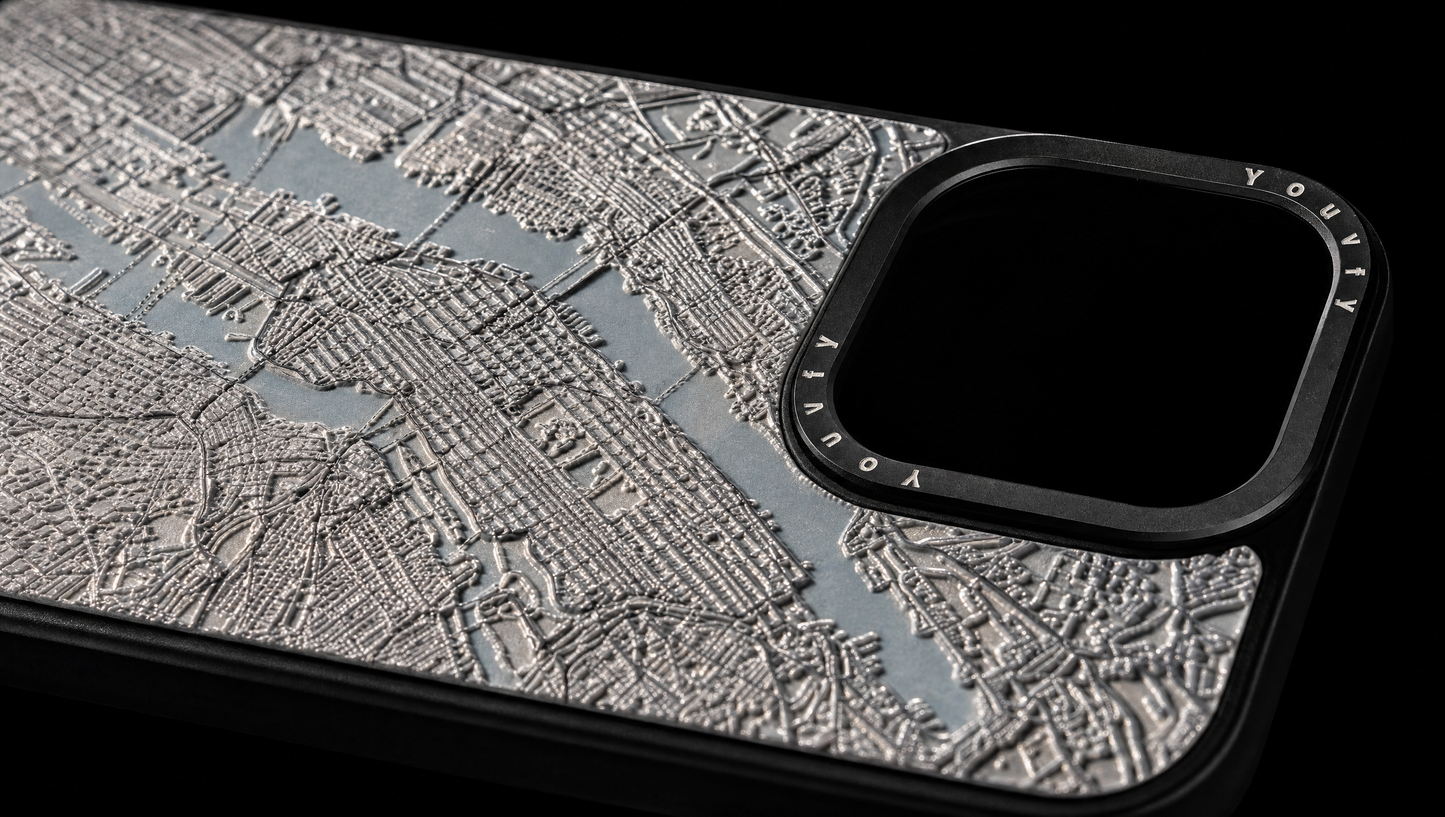 Dramatic macro showing the raised 2.5D textured street grid of a Youvfy New York map iPhone case