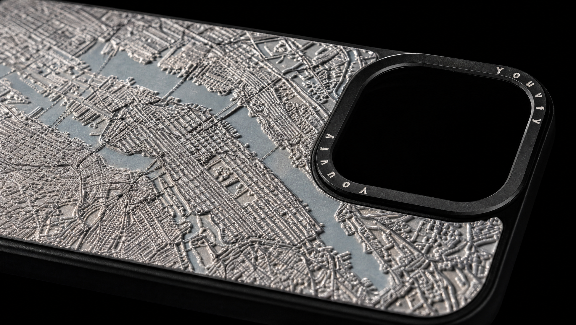 Dramatic macro showing the raised 2.5D textured street grid of a Youvfy New York map iPhone case