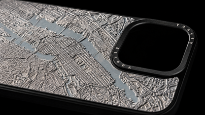 Dramatic macro showing the raised 2.5D textured street grid of a Youvfy New York map iPhone case