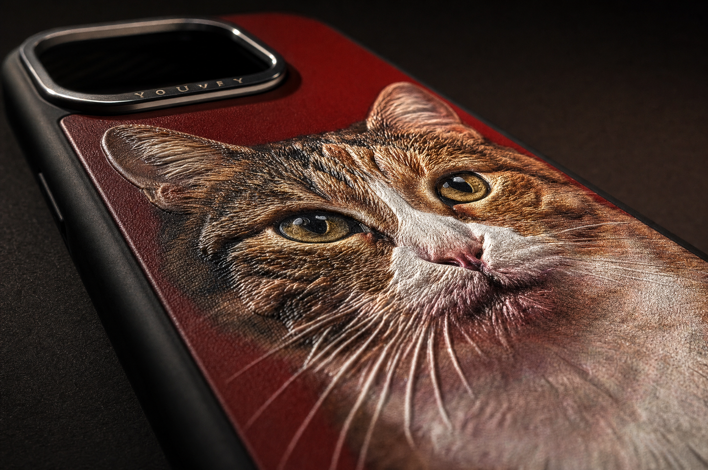 Macro detail of a Youvfy iPhone case showing the raised tabby cat portrait texture