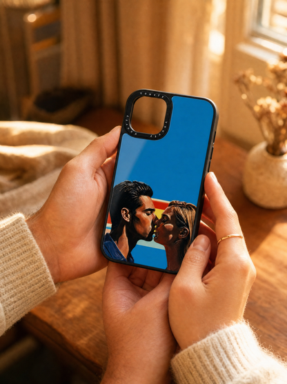 Couple's hands tenderly holding a Youvfy flat-printed iPhone case with an illustrated couple portrait, golden hour